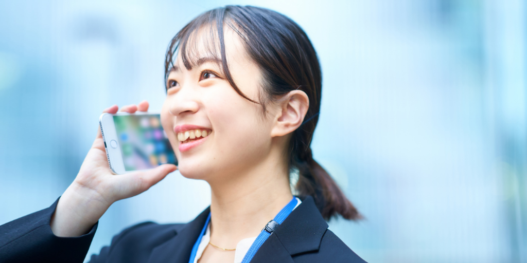女性がスマホ耳に当てて笑っている